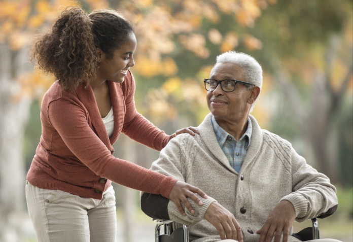 Hypothetical caregiver and a POMALYST® (pomalidomide) patient with relapsed/refractory multiple myeloma outdoors smiling at each other